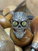 Load image into Gallery viewer, This is Peridot Skull Ring in Sterling Silver with intricate detail, looking like something straight out of Terminator. The Peridot eyes make this piece really pop when sparkling in the light
